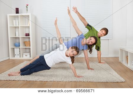 Fit Family Doing Side Plank Yoga At Home