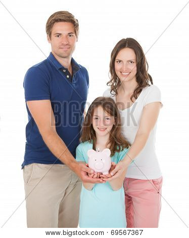 Happy Family Holding Piggy Bank Together