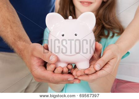 Family Holding Piggy Bank