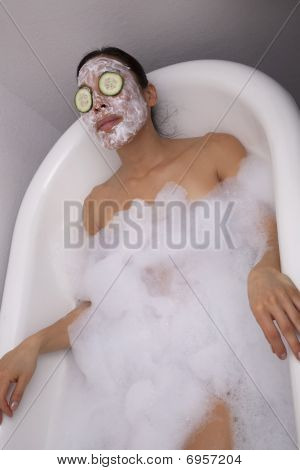 Frau in Bad mit Sahne und Gurken