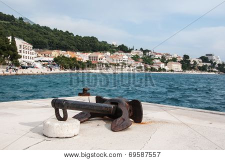 Old rusty ship anchor in the harbor in Podgora, Croatia