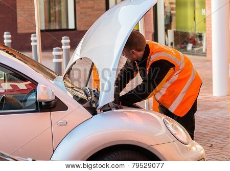 Mechanic Working On A Car Wth The Bonnet (hood) Up