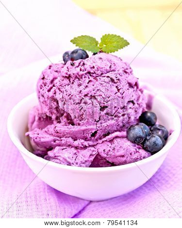 Ice cream blueberry with mint in bowl on purple napkin