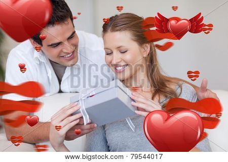 Woman opening the gift she got from her boyfriend against love heart pattern