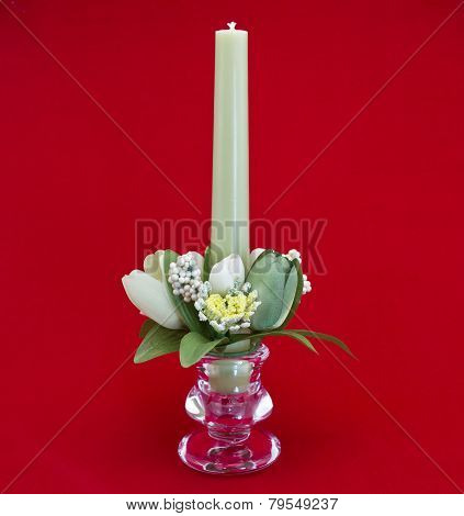 Candle holder with green pillar candle against red background
