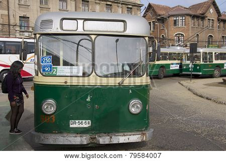 Lady enters old trolleybus in Valparaiso, Chile