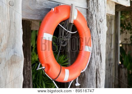 summer, beach, swimming and life saving concept - lifebuoy or life preserver hanging on rescue booth