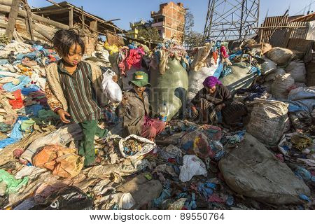 KATHMANDU, NEPAL - CIRCA DEC, 2013: Unidentified child and his parents during lunch in break between working on dump. Only 35% of population Nepal have access to adequate sanitation.