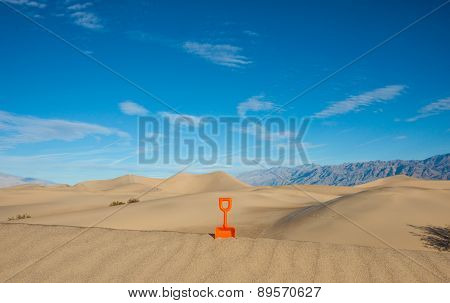 Plastic Shovel Standing In A Sand Dune