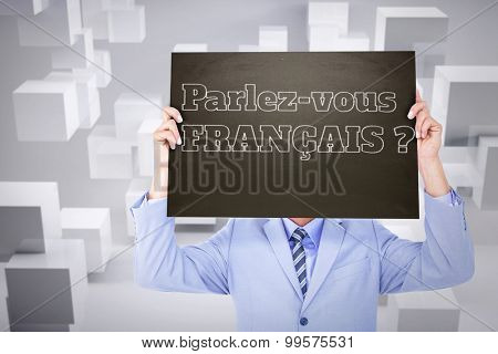 Businessman showing board against room with floating cubes