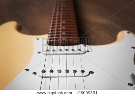 Electric guitar on wooden background, close up