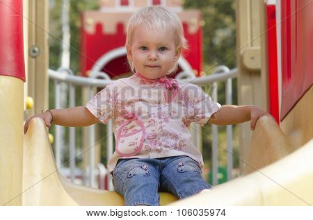 Litlle girl on a swing at the kids playground