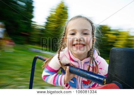 Little Girl Smiling On A Moving Merry-go-round