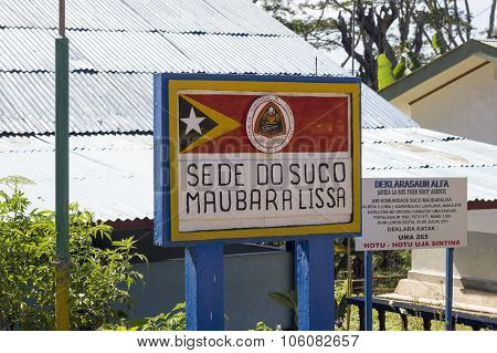 Sign On Maubara Lissa Municipality Headquarters With Timorese Flag, Coat Of Arms And A Sign Enumerat