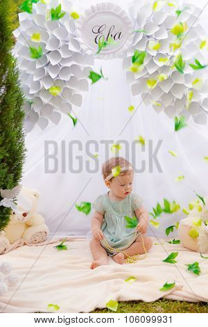 Baby playing in a park near the tents of baldachin
