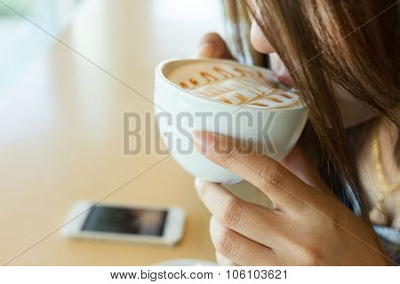 beautiful girl drinking hot coffee or tea in coffee cafe