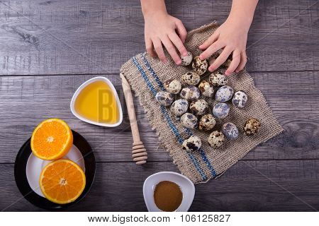 Children's hand holds the eggs of quail