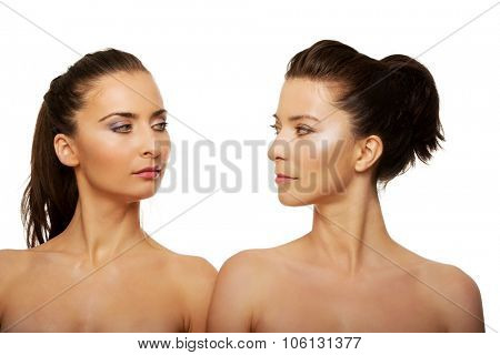 Two attractive topless sisters with make up.