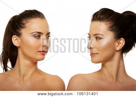 Two attractive topless sisters with make up.