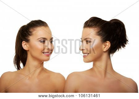 Two attractive topless sisters with make up.