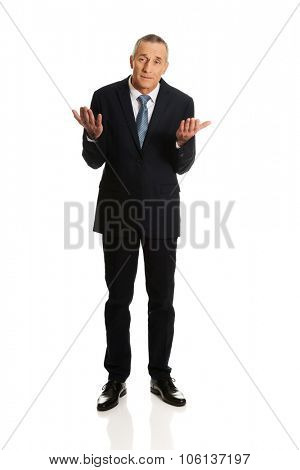 Full length businessman making undecided gesture.