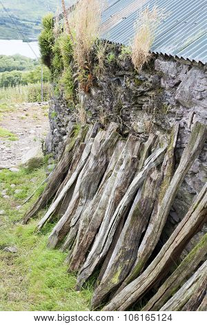 Wood Stacked Against A Farm Wall