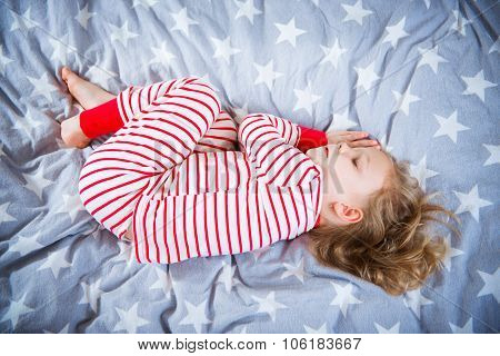 Cute Little Girl Sleeps In Pajames On Bed