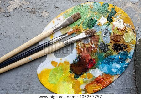 Brushes And Colorful Abstract Oil Colors Paiters Pallet, On Grunge Background
