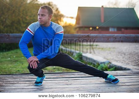 Sport Man Stretching Aoutdoors Doing Exercises Evening At Sunset. Fitness Concepts