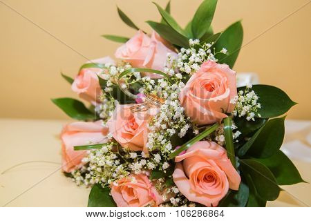 Two  wedding rings on a bouquet of pink roses