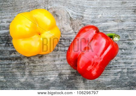 Two Ripe Peppers On The Old Gray Wooden Board