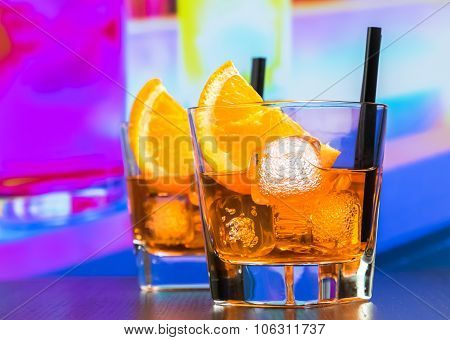 Two Glasses Of Spritz Aperitif Aperol Cocktail With Orange Slices And Ice Cubes On Bar Table, Disco