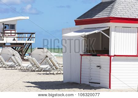 Sun Umbrellas And Rescue  Buildings On The Beach Of Ocean. Miami Beach, Florida.