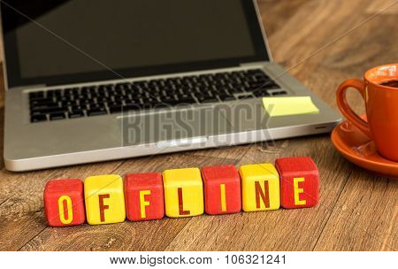 Offline written on a wooden cube in front of a laptop