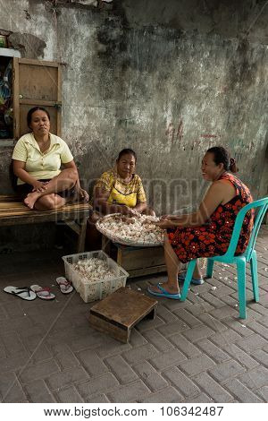 Indonesian Woman Peel Garlic In Manado Shantytown