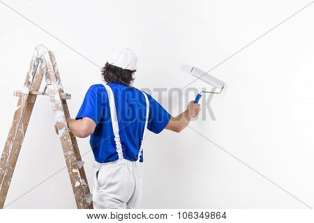 Painter Man At Work Climbing A Vintage Wooden Ladder And Painting With Paintroller