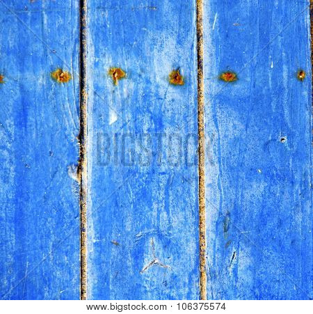 Stripped Paint In The Blue Wood Door And Rusty Nail