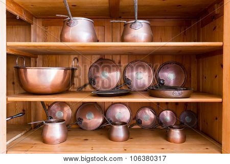 Set of vintage ibriks and pans on the wooden shelf