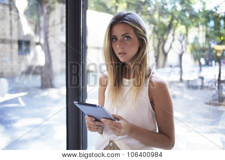 Attractive female student using digital tablet during her recreation time