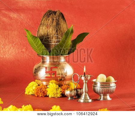 hindu puja elements, kalash with coconut and mango leaves,diya, haldi kumkum and indian sweet pedha