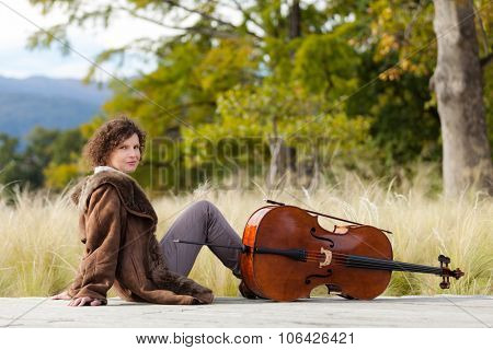 Portrait of young cellist, outdoors
