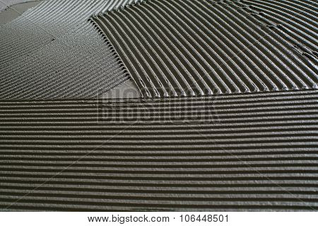 Notched Troweling Mortar Onto A Concrete Floor In Preparation