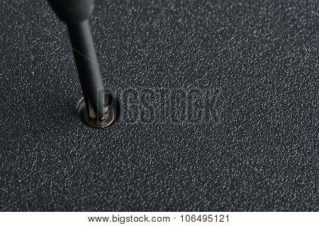 Screwdriver And Screw On A Laptop