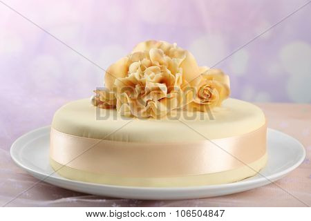 Cake with sugar paste flowers, on light background