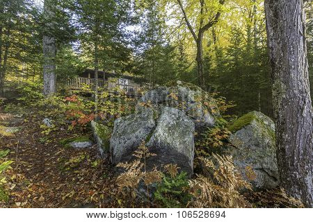 Cottage In Autumn With Large Rocks In The Foreground