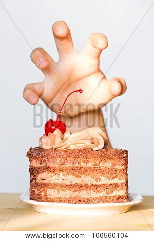 Greed for sweets concept with hand and chocolate cake