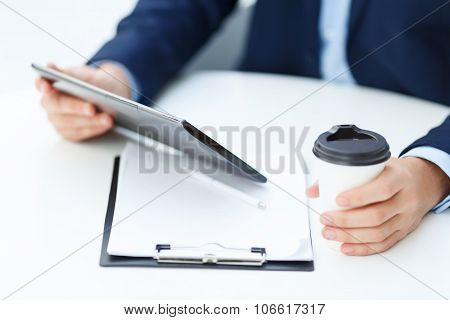 Office worker with tablet and papercup of coffee.