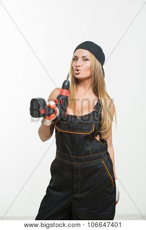 Young sexy female holding a cordless screwdriver