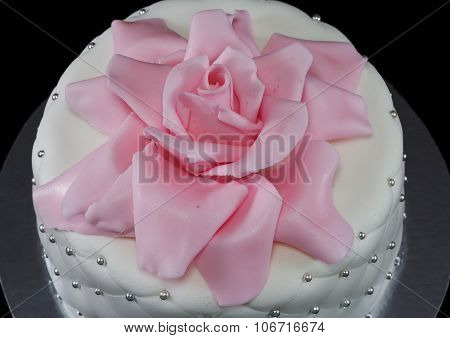 One white cake decorated with a pink rose