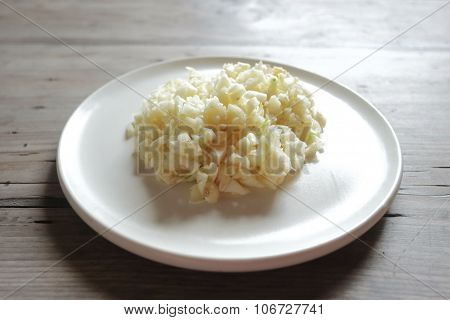 ground fresh garlic on white plate